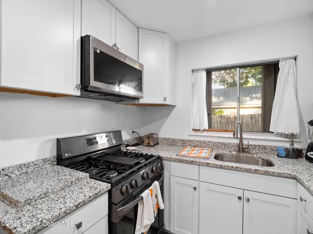 a kitchen with granite countertop a stove and a sink