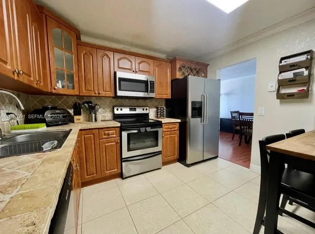 a kitchen with stainless steel appliances granite countertop a refrigerator stove top oven a sink and dishwasher