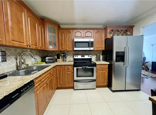 a kitchen with stainless steel appliances granite countertop a refrigerator stove and sink