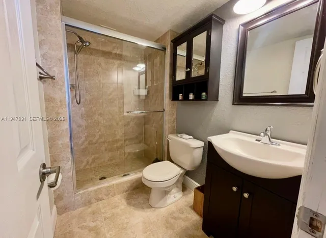 a bathroom with a sink toilet vanity and shower