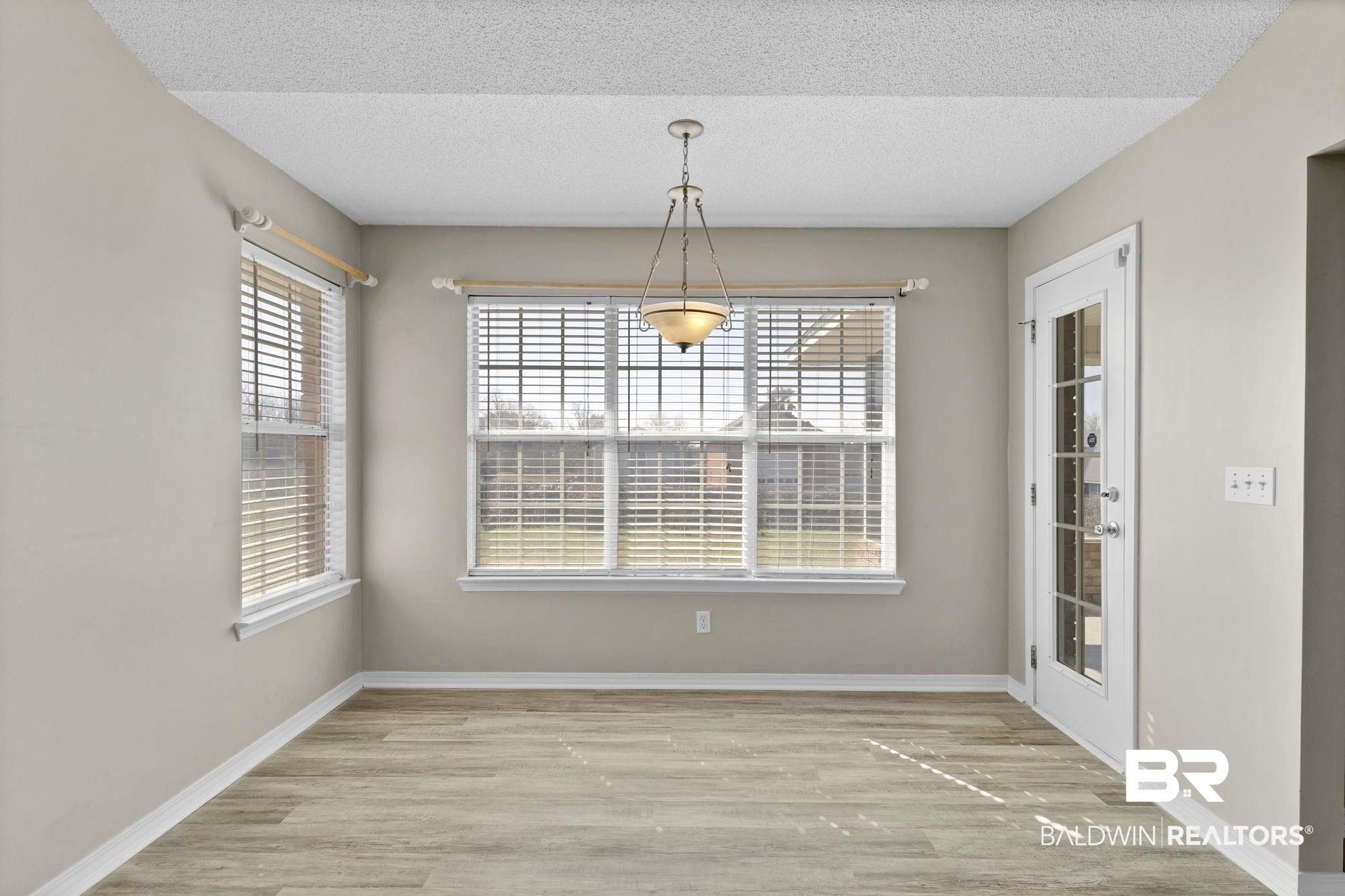 10238 Grove Drive Fairhope, AL 36532 - Photo 11 of 39 Kitchen dinette with wood type flooring, lots of natural light and entrance into the sunroom.
