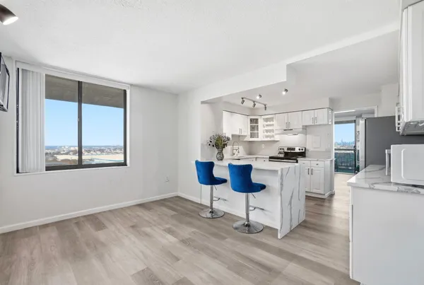 a kitchen with white cabinets and chairs