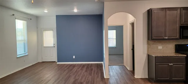 a view of a hallway with wooden floor and cabinet