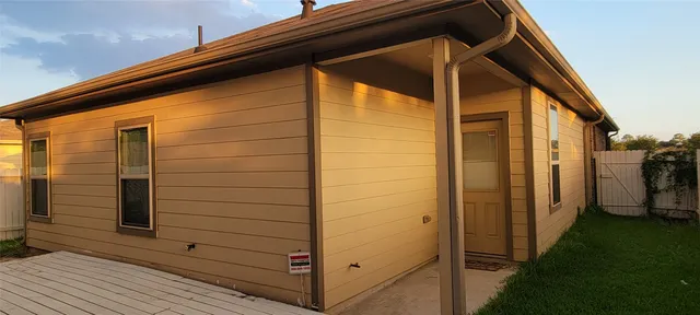 a view of a house with brick walls and a yard with plants