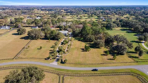 a view of a white house with a yard and potted plants
