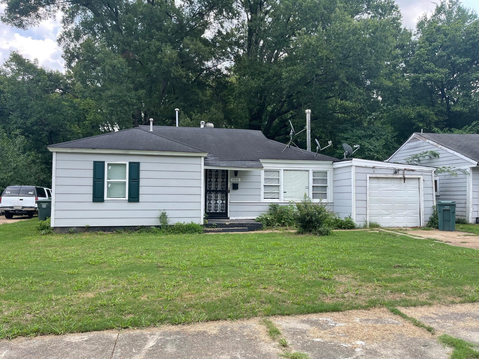 1666 Russwood Road Memphis, TN 38108 - Photo 1 of 1 View of front of property featuring a garage and a front yard