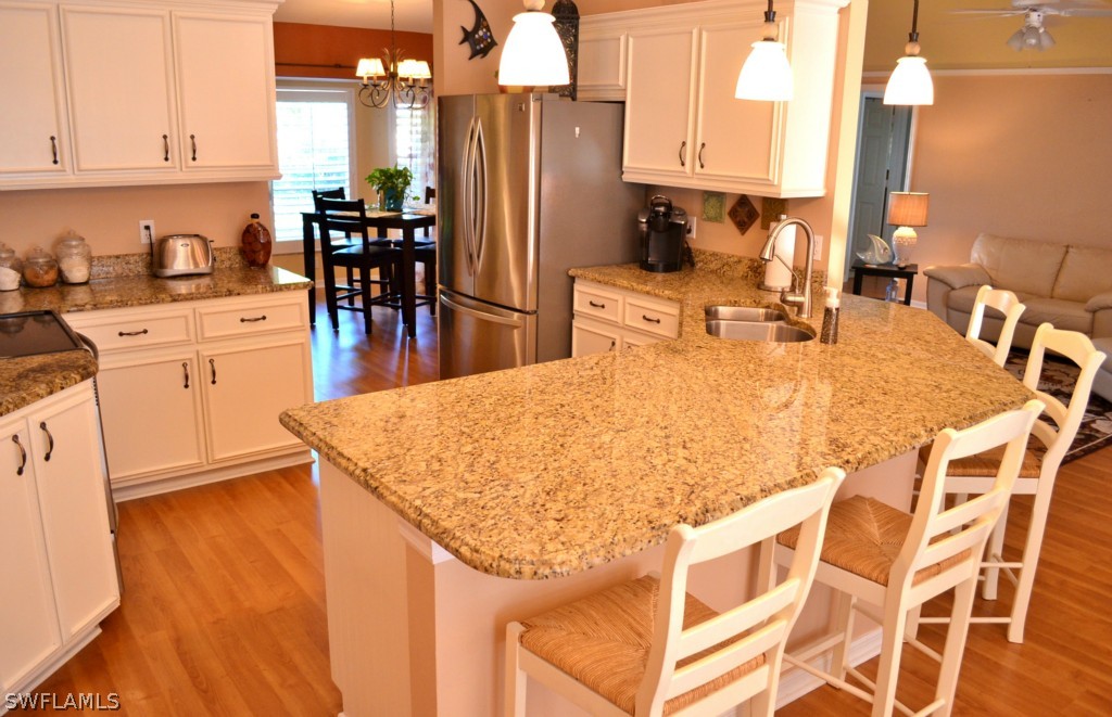 17432 Georgia Road Fort Myers, FL 33967 - Photo 8 of 20 a kitchen with stainless steel appliances kitchen island granite countertop a table chairs sink and cabinets