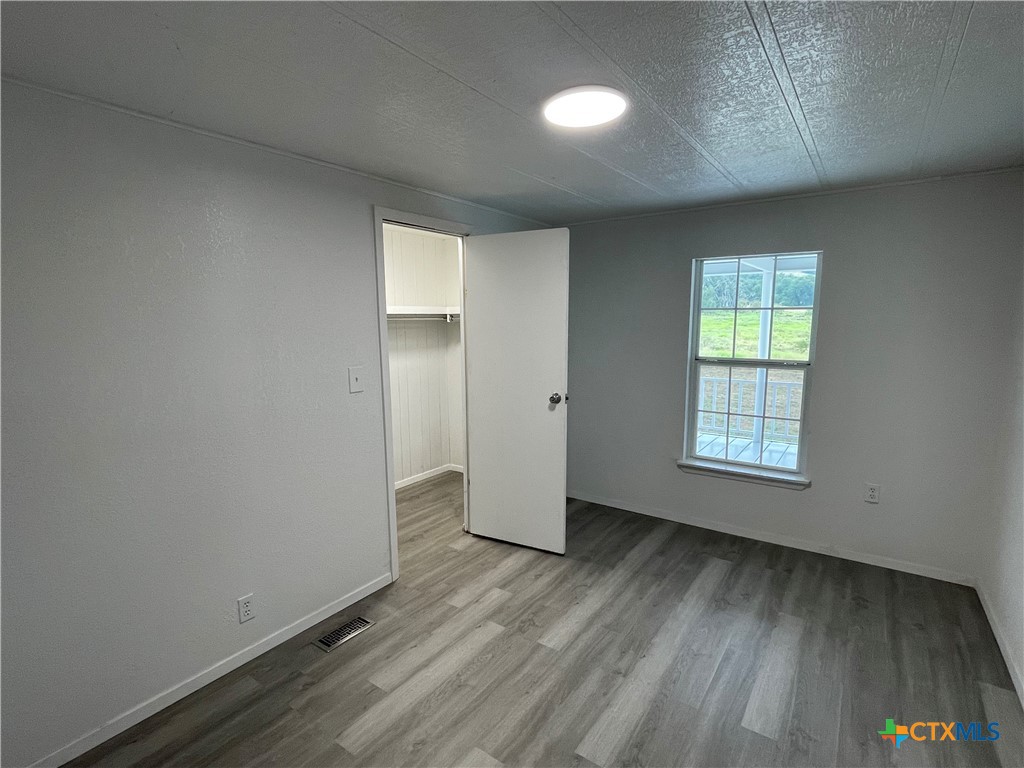 60 County Road 304 Goldthwaite, TX 76844 - Photo 10 of 23 an empty room with wooden floor and windows