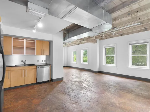 a large kitchen with stainless steel appliances granite countertop a stove and cabinets
