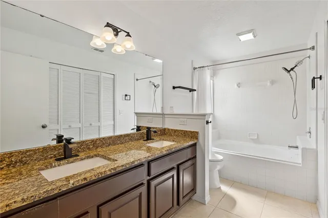 a bathroom with a granite countertop sink and cabinets
