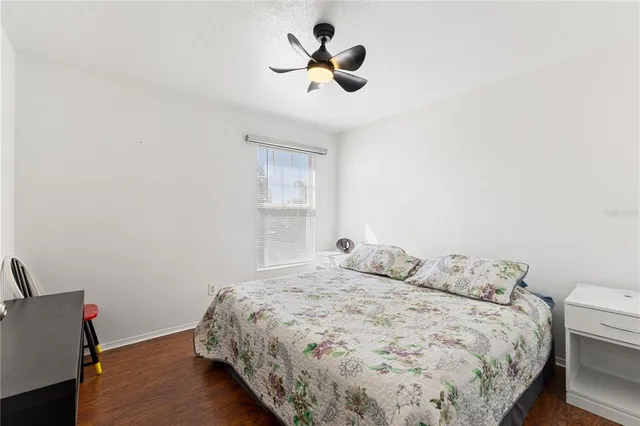a bedroom with a bed bookshelf and a painting on the wall