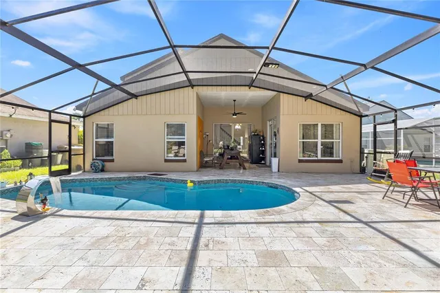 an aerial view of a house with swimming pool and an outdoor seating