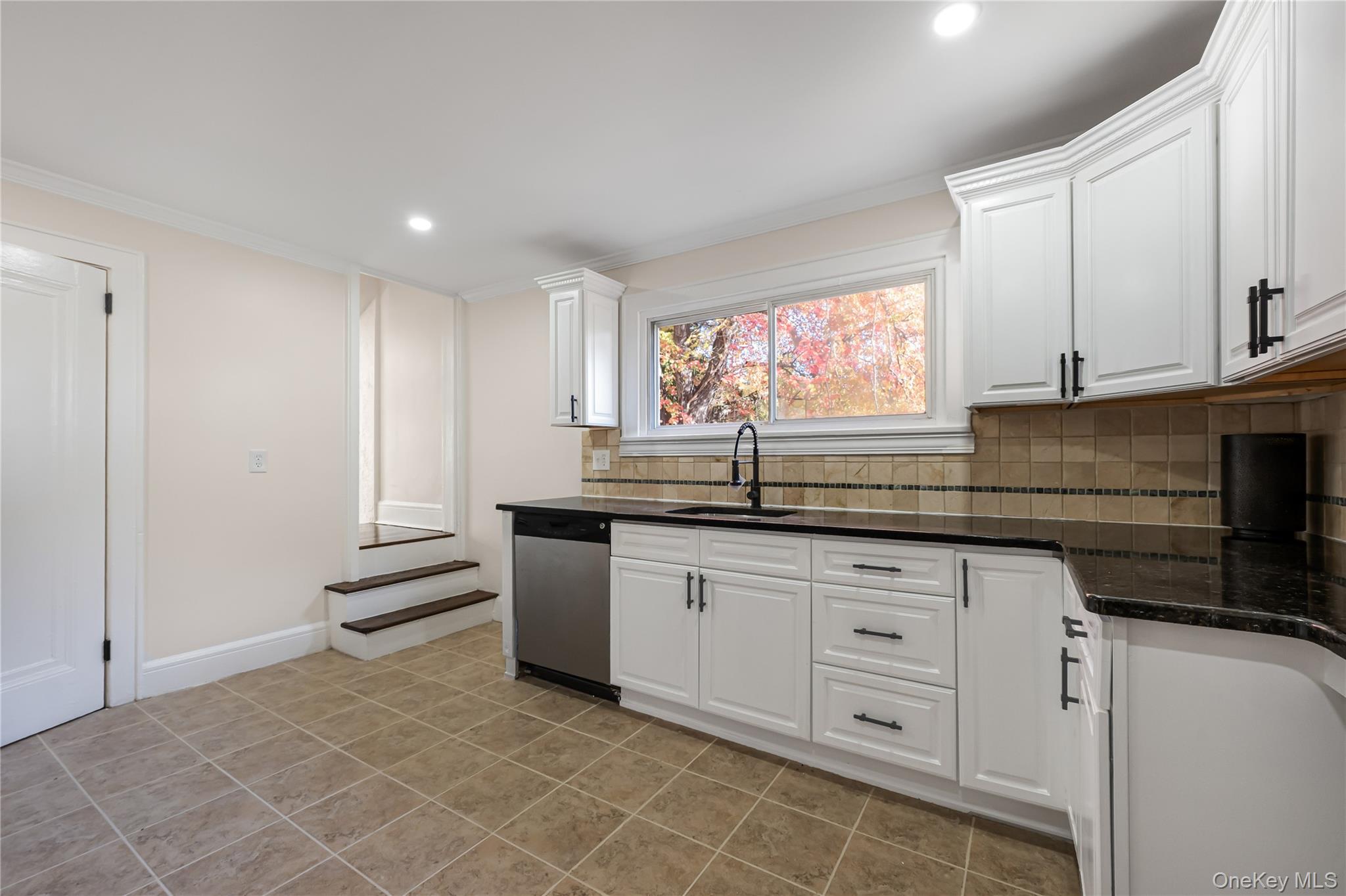 39 Hillcrest Road Hartsdale, NY 10530 - Photo 18 of 42 a kitchen with granite countertop a sink white cabinets and a dishwasher next to a window