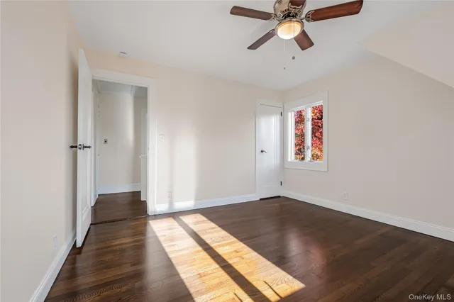 a view of empty room with wooden floor and window
