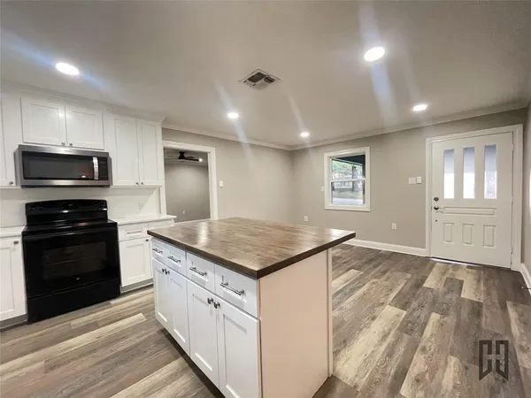 a kitchen with granite countertop a stove sink and microwave