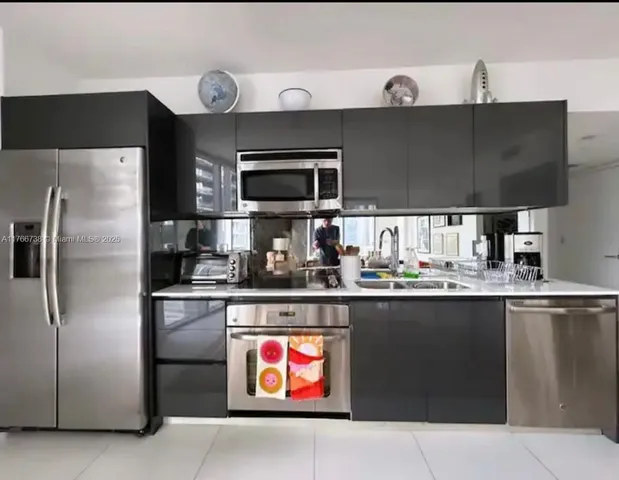 a kitchen with stainless steel appliances a sink and a refrigerator