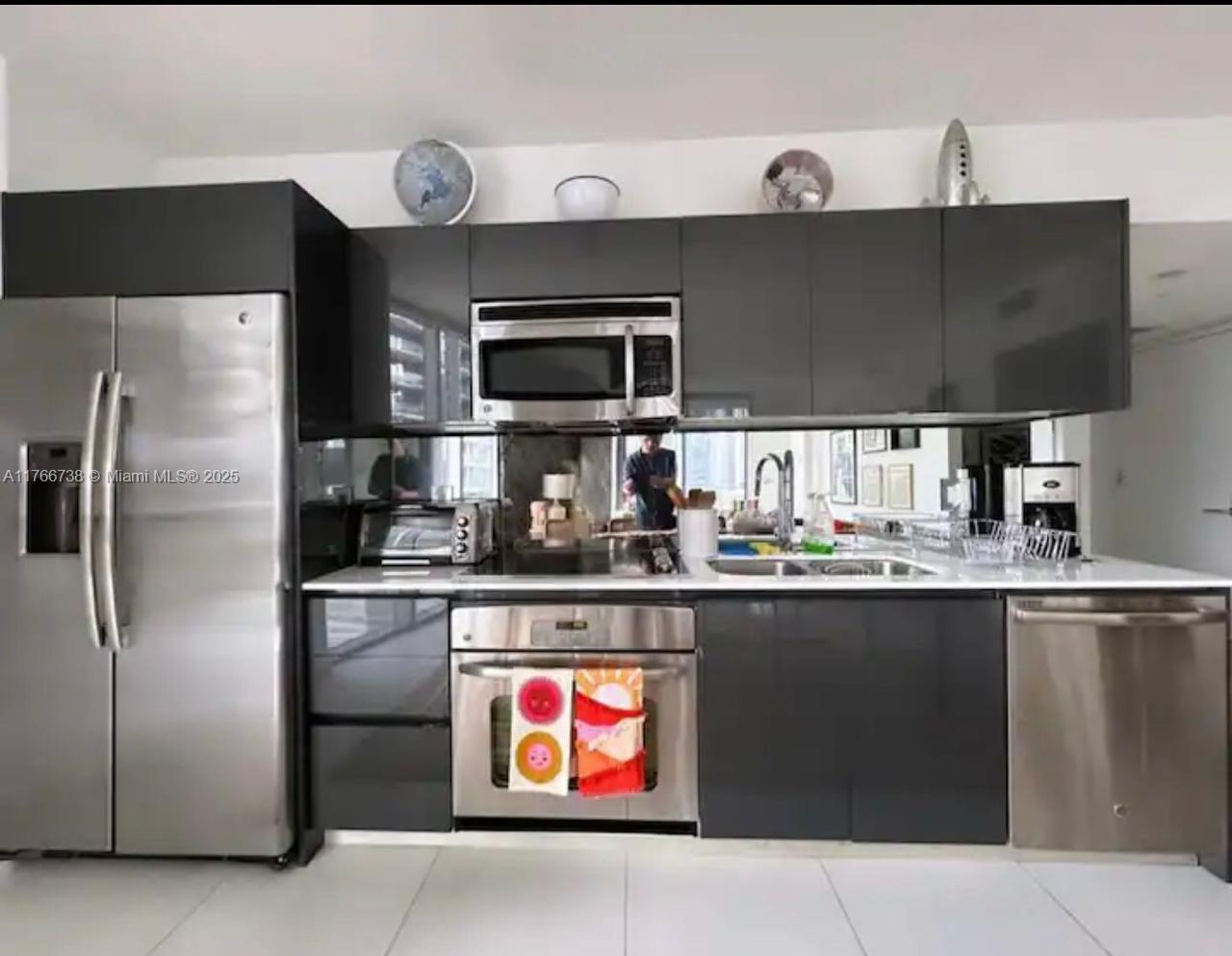 31 Southeast 6th Street, Unit 1601 Miami, FL 33131 - Photo 3 of 14 a kitchen with stainless steel appliances a sink and a refrigerator