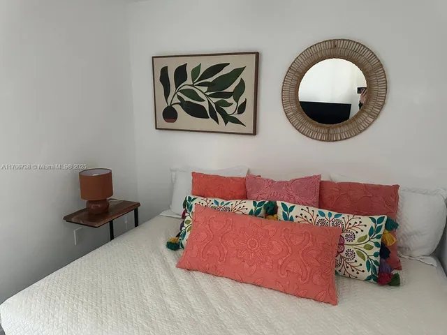 a bed room with a bed and a painting on the wall