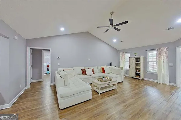 a living room with furniture and wooden floor