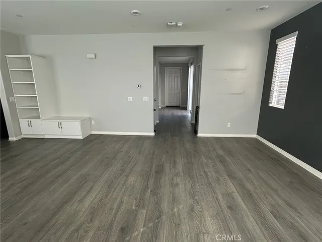 a view of a hallway with wooden floor and entryway