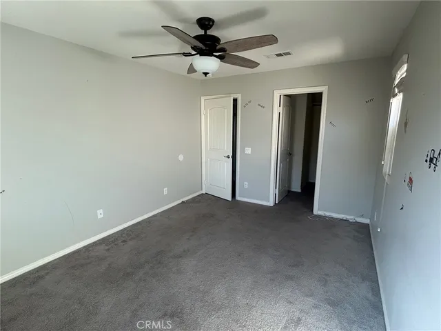an empty room with a window and a fan
