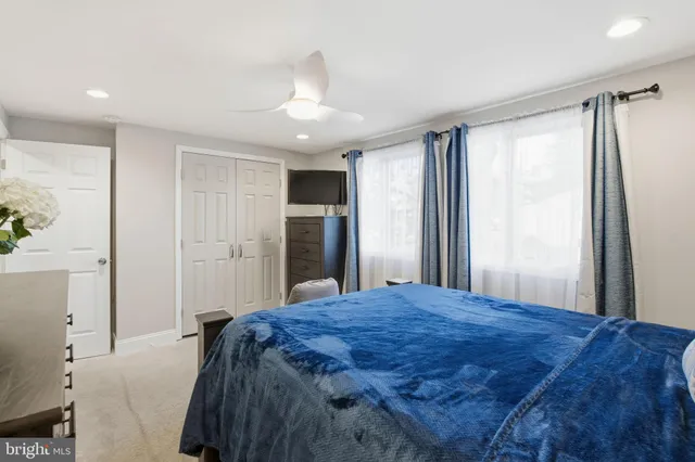 a large bed in a white room with closet and bathroom