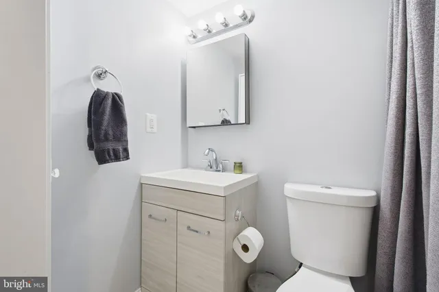 a bathroom with a toilet sink and mirror