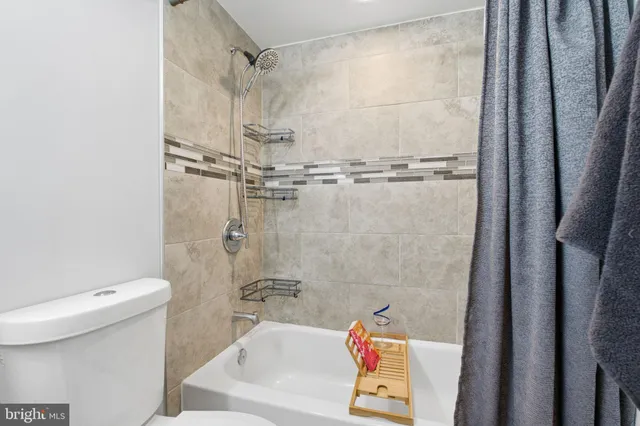 a bath tub sitting next to a white toilet and sink