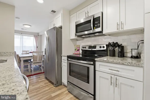 a kitchen with stainless steel appliances granite countertop a stove microwave and refrigerator