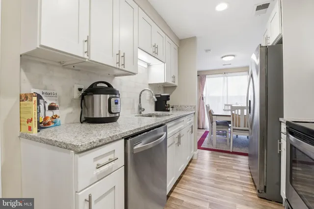 a kitchen with stainless steel appliances granite countertop a sink and cabinets