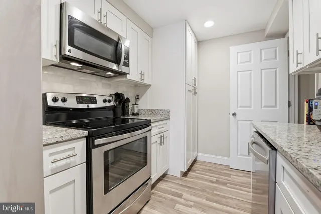 a kitchen with stainless steel appliances granite countertop a stove microwave and sink