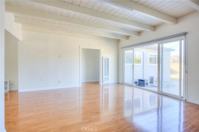 a view of a big room with wooden floor and windows