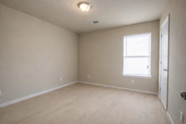 an empty room with a window and a ceiling fan