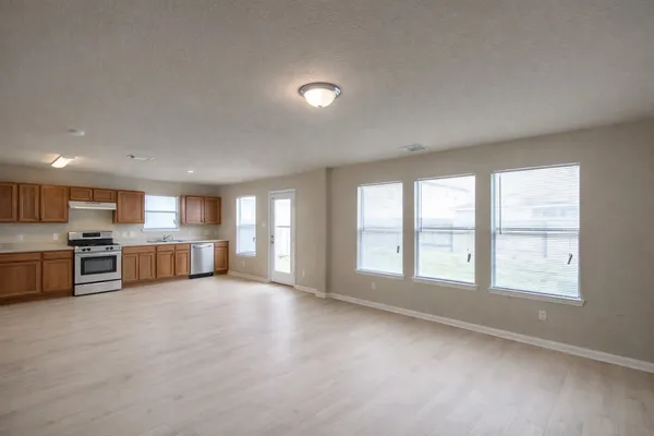 an empty room with wooden floor and mirror