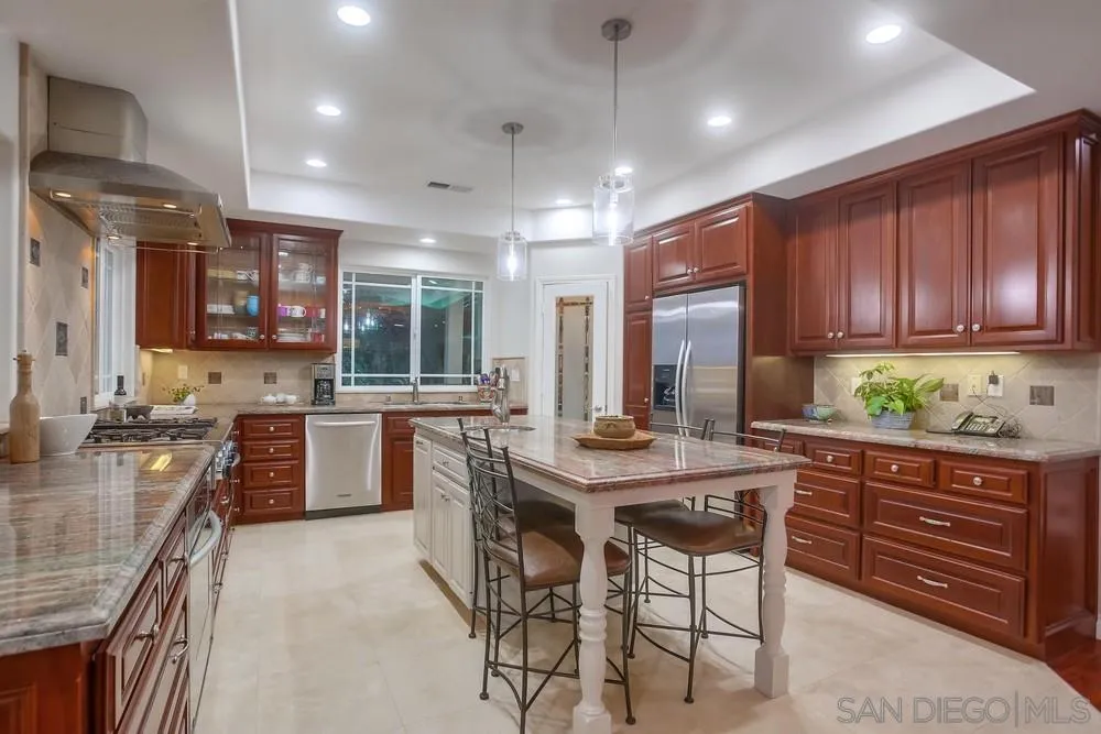 2234 Ivy Road Oceanside, CA 92054 - Photo 14 of 29 a kitchen with stainless steel appliances granite countertop wooden cabinets a stove top oven a sink and dishwasher