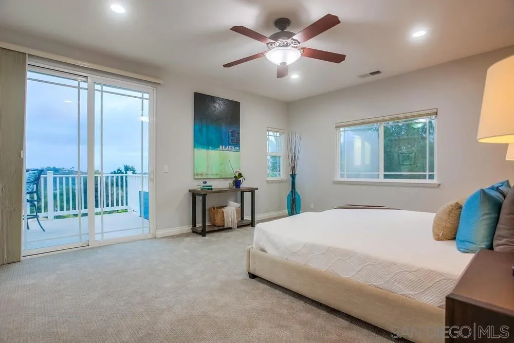 2234 Ivy Road Oceanside, CA 92054 - Photo 18 of 29 a spacious bedroom with a balcony a bed and a chandelier