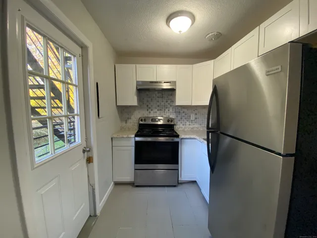 a kitchen with a refrigerator and a stove