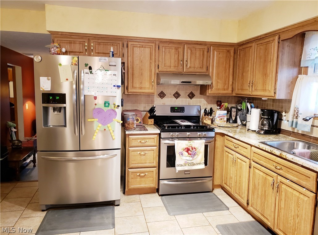 8644 Root Road North Ridgeville, OH 44039 - Photo 11 of 32 Kitchen featuring appliances with stainless steel finishes, light tile floors, and tasteful backsplash