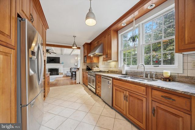a large kitchen with granite countertop a large window and stainless steel appliances