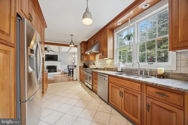 a large kitchen with granite countertop a large window and stainless steel appliances