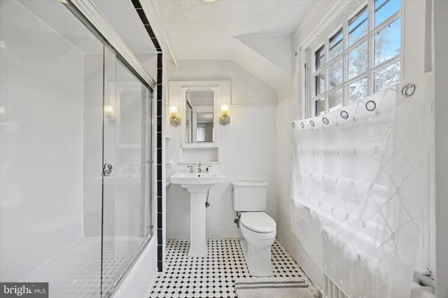 a bathroom with a toilet a sink and shower