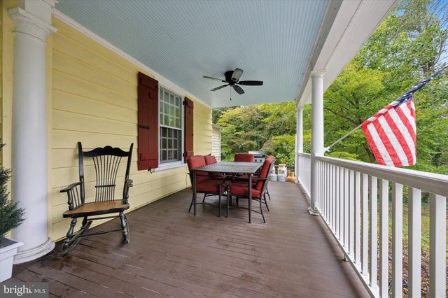 a view of a porch with furniture and a yard