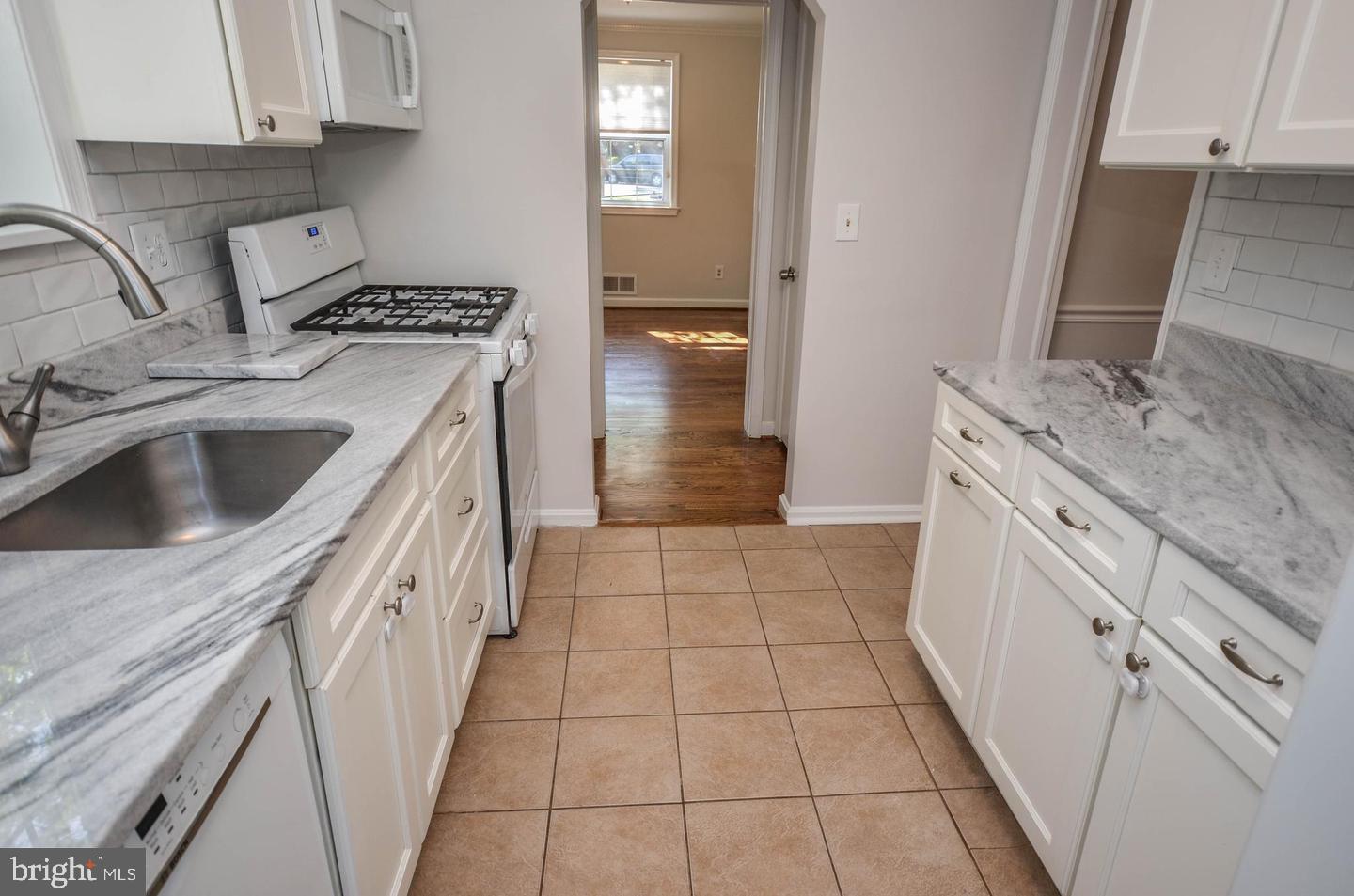 2315 Plyers Mill Road Silver Spring, MD 20902 - Photo 12 of 28 a kitchen with a sink stove and cabinets