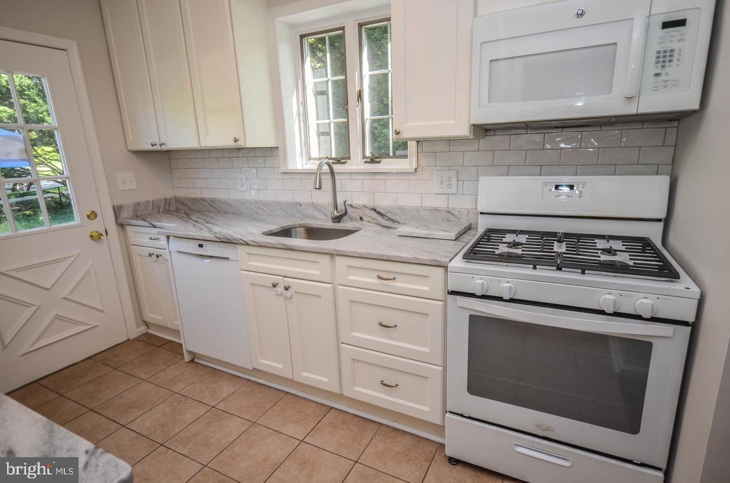 2315 Plyers Mill Road Silver Spring, MD 20902 - Photo 13 of 28 a kitchen with granite countertop white cabinets and white appliances