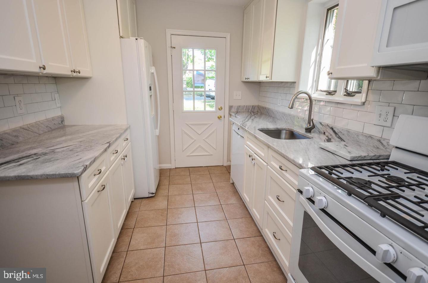 2315 Plyers Mill Road Silver Spring, MD 20902 - Photo 14 of 28 a kitchen with a sink stove top oven and cabinets