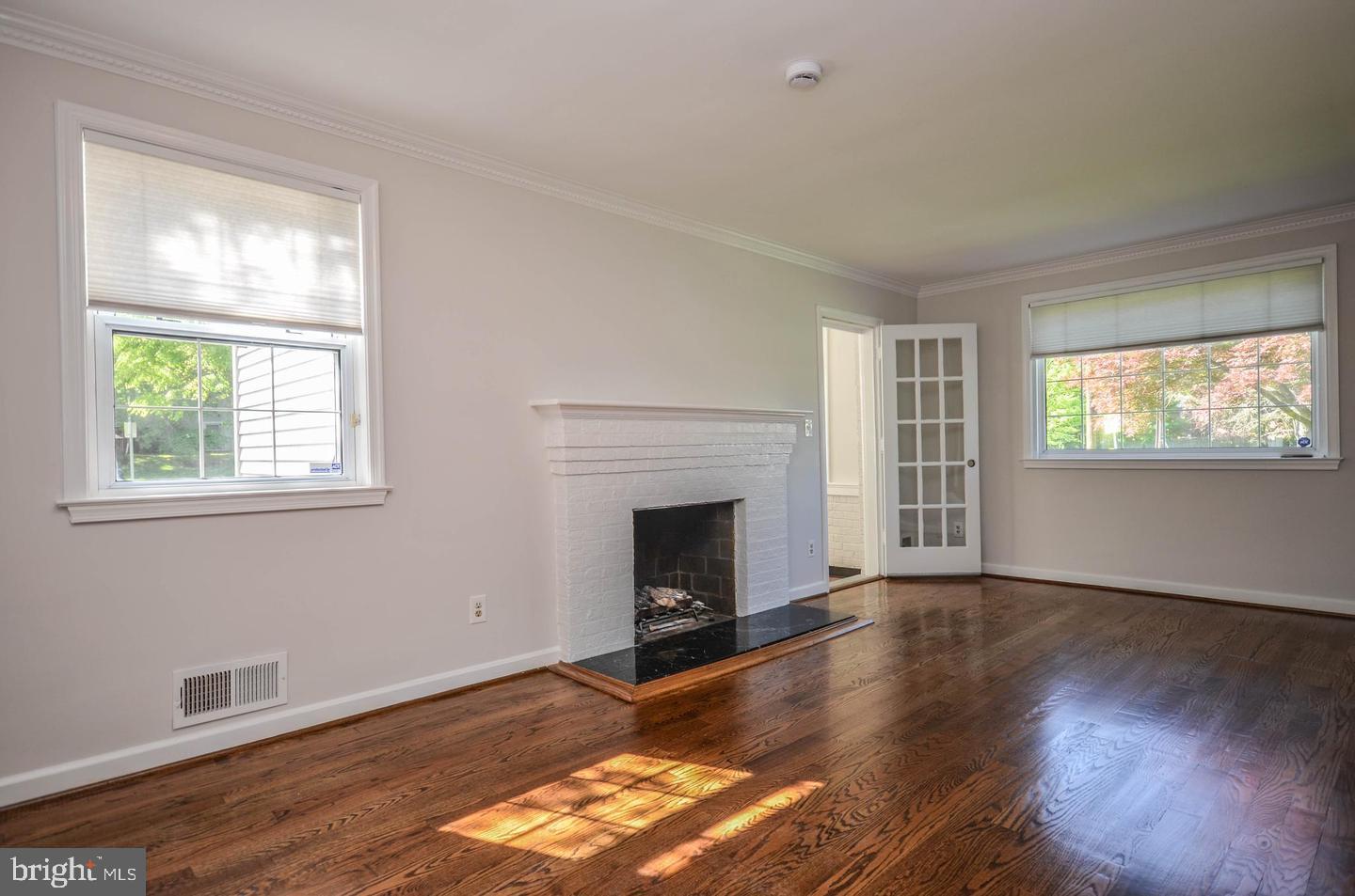 2315 Plyers Mill Road Silver Spring, MD 20902 - Photo 4 of 28 a view of an empty room with wooden floor fireplace and a window