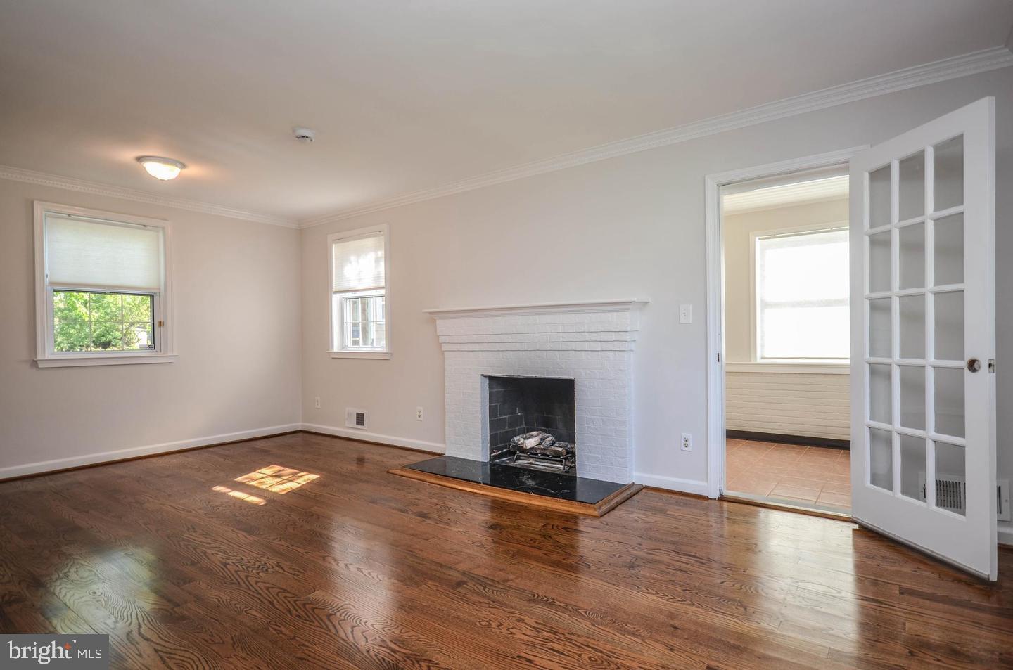 2315 Plyers Mill Road Silver Spring, MD 20902 - Photo 5 of 28 an empty room with wooden floor fireplace and windows