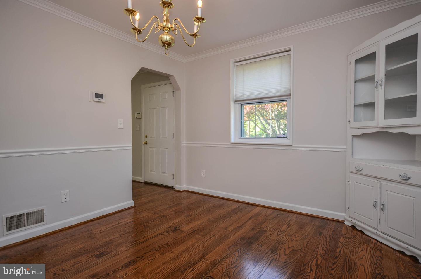 2315 Plyers Mill Road Silver Spring, MD 20902 - Photo 7 of 28 an empty room with wooden floor cabinet and windows