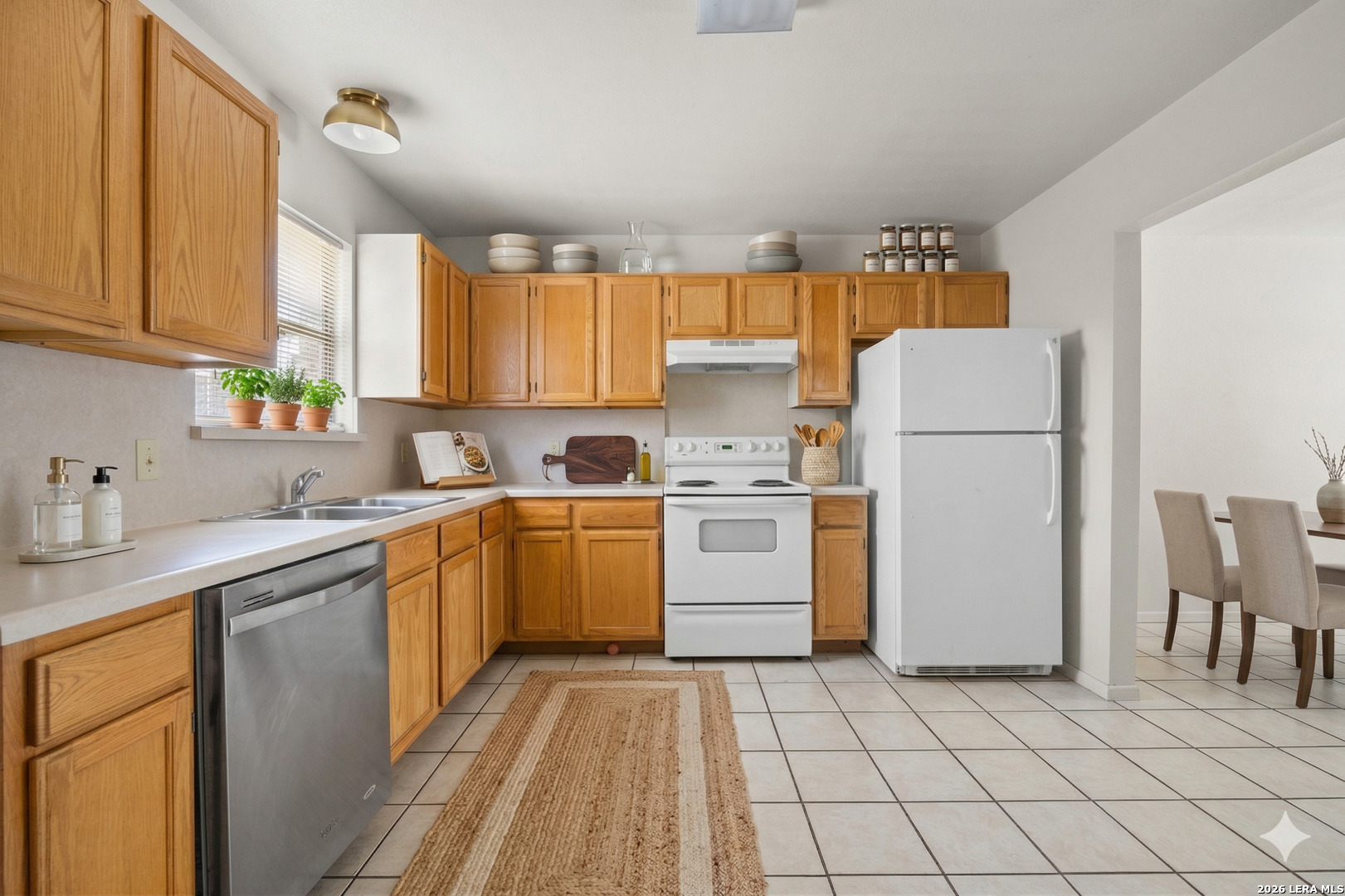 1118 West Goodwin Street Pleasanton, TX 78064 - Photo 13 of 23 a kitchen with a sink a refrigerator and cabinets