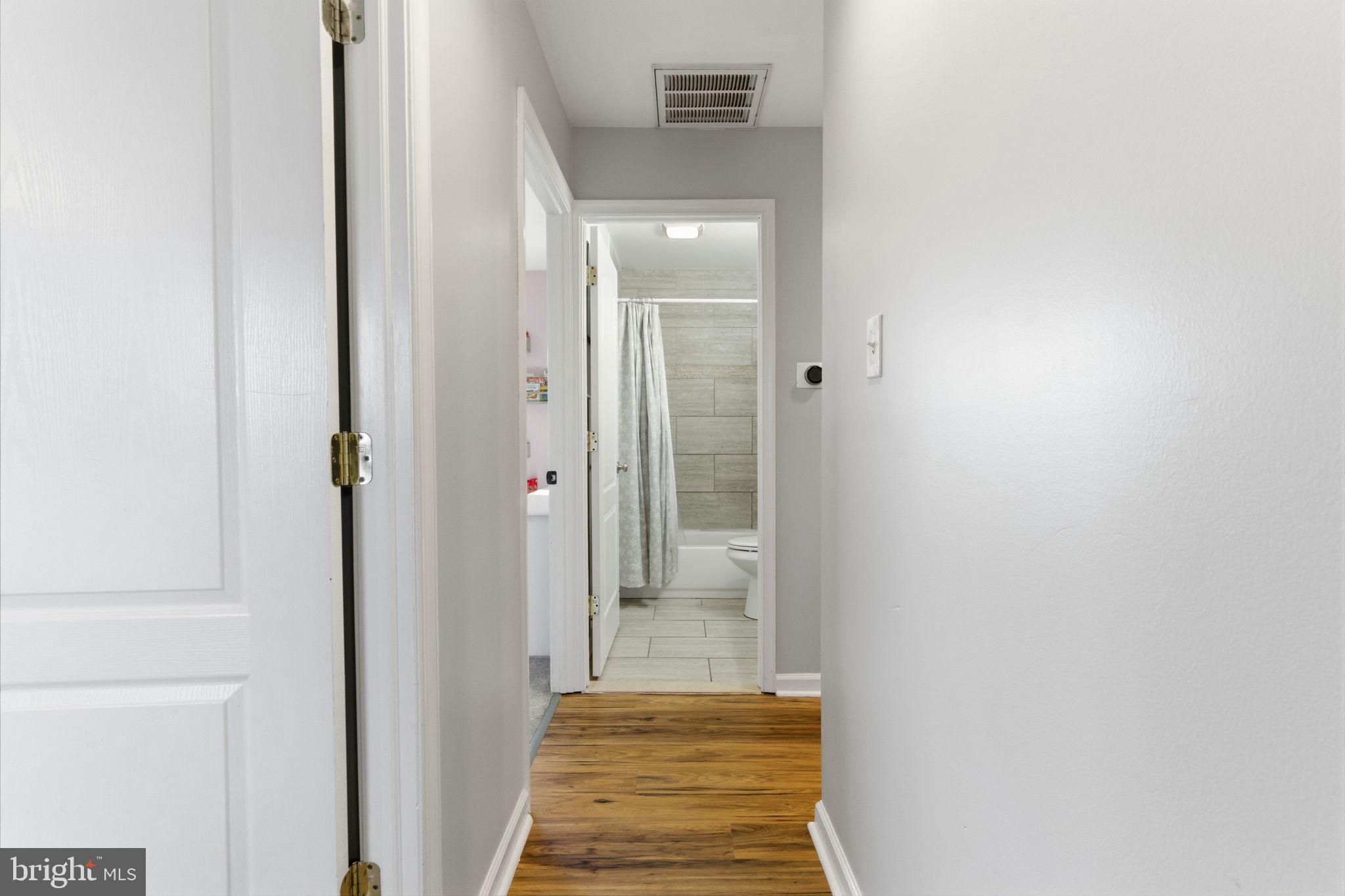 62 Oldbrook Road Levittown, PA 19057 - Photo 15 of 18 a view of a hallway with wooden floor and a bathroom